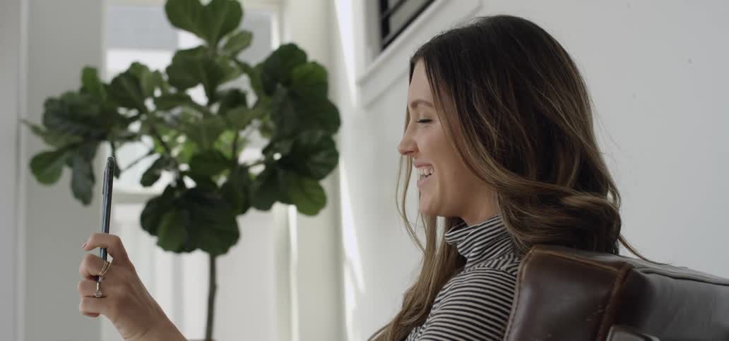 Woman smiling and laughing during video chat on cell phone