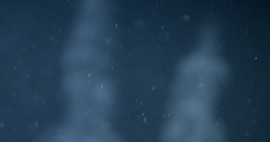 Soft focus glinting snowflakes in the night