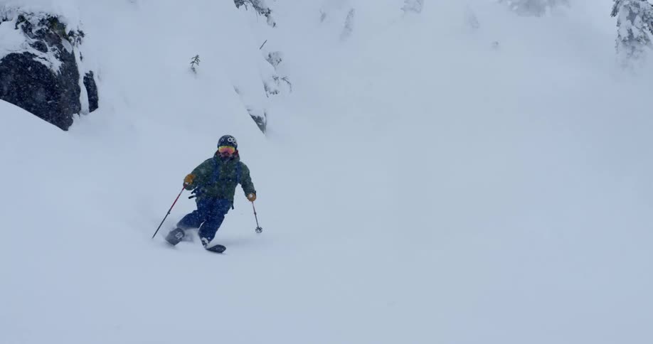 A person skis down a snow covered mountain