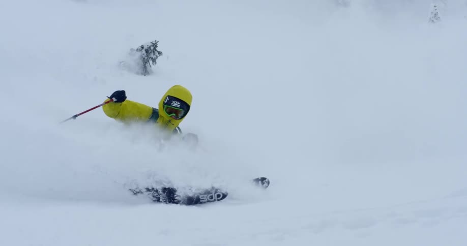 A person sprays through deep powder