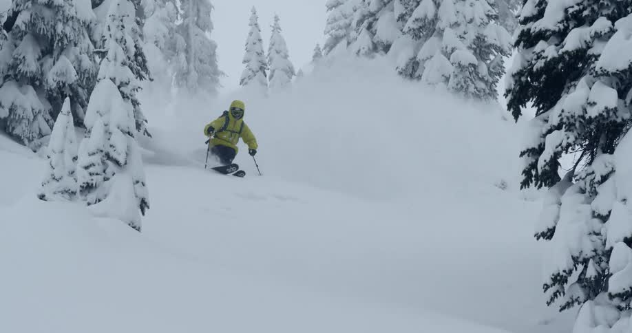 A skier carves down a snowy hill