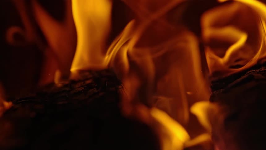 Flames rise from a burning log