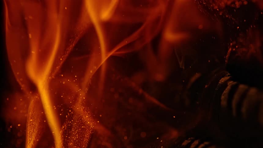 Flames rise from a burning log