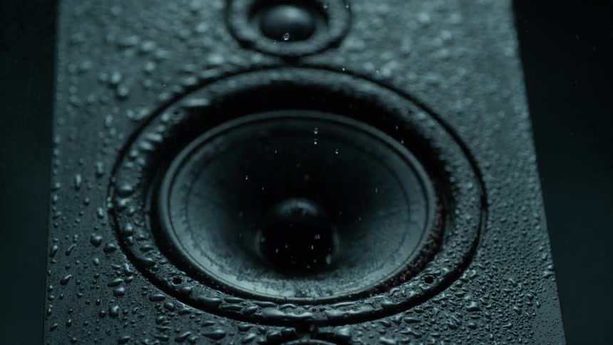 Water droplets fly off a vibrating speaker