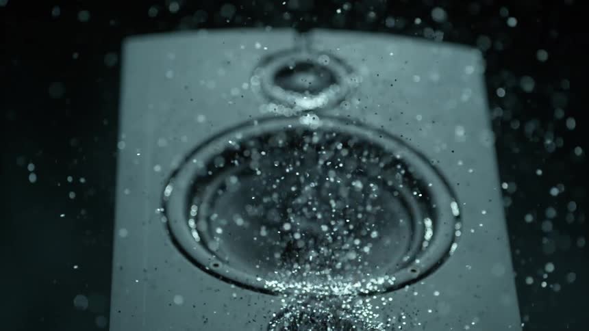 A thumping speaker blows out a pile of silver glitter