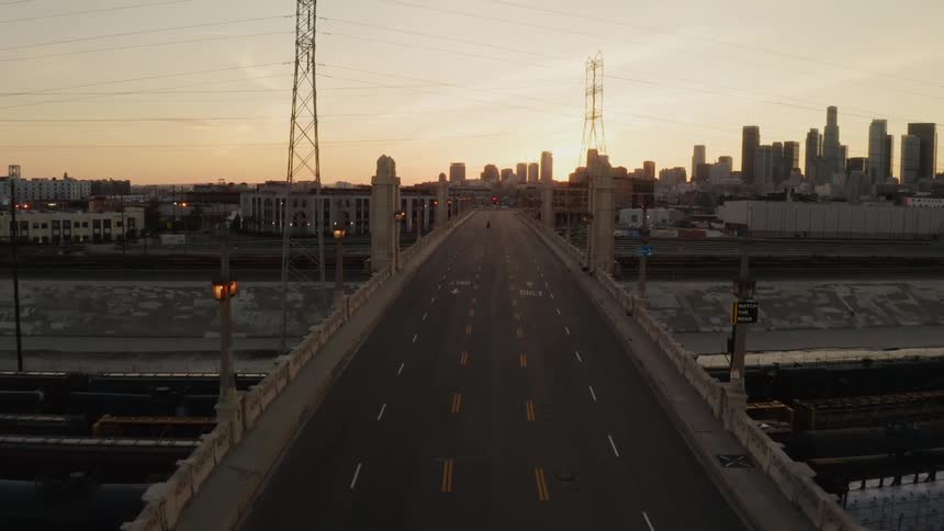 Bridge over canal in front of city skyline at dawn