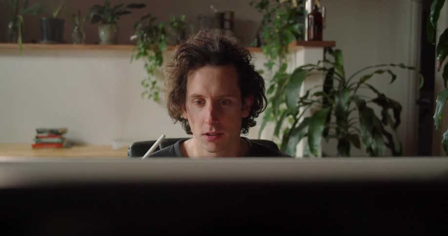 Man sits before monitor talking