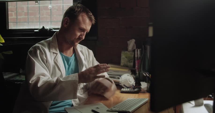 A man sits at his desk and works on his computer