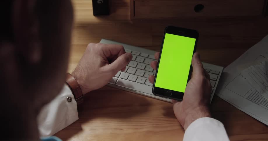 A man is using a smart phone indoors