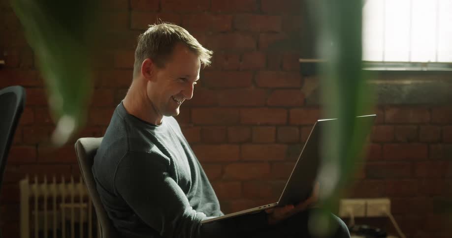 A man is video chatting with someone on a laptop