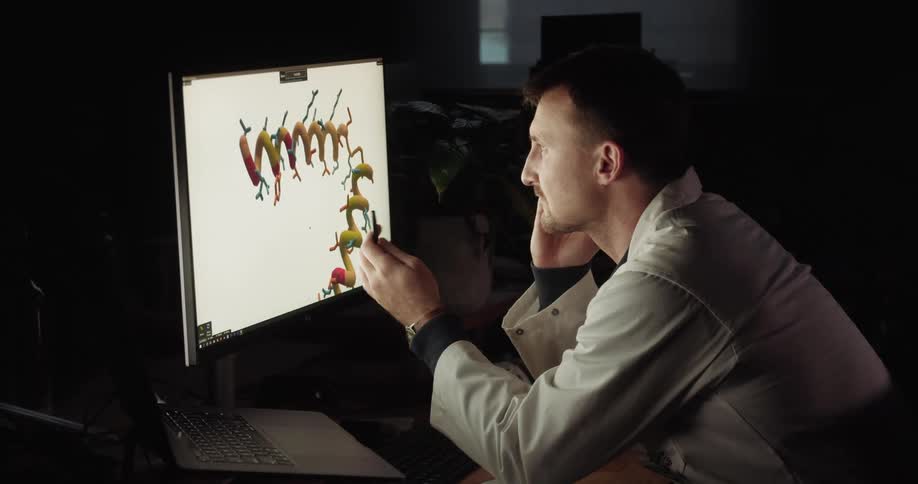 A man looks at an image on his computer and talks on the phone