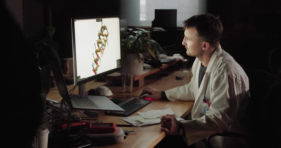 A man sits at his desk and uses a computer