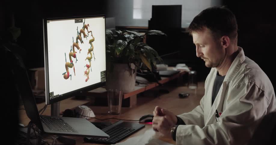 Man looks at a computer monitor and types on a keyboard