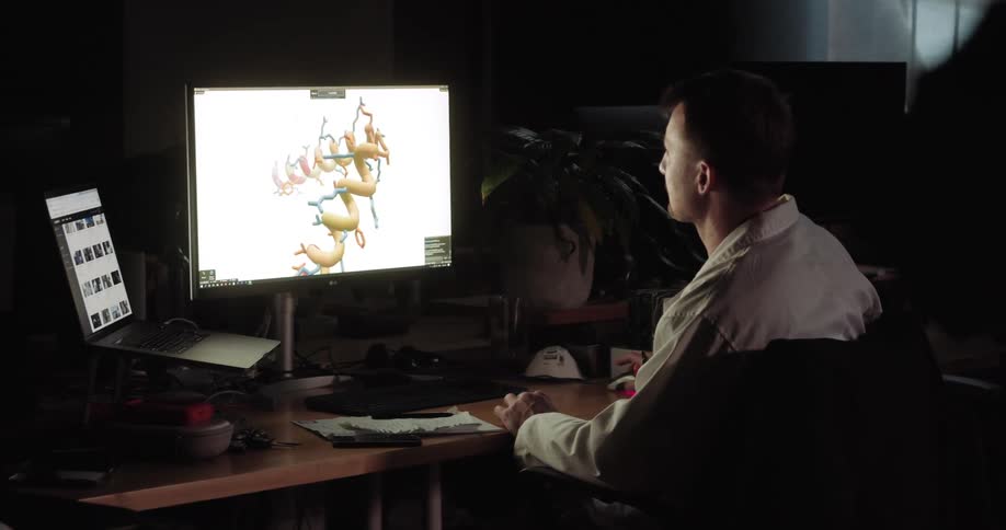 Man working on computer graphics in an office at night