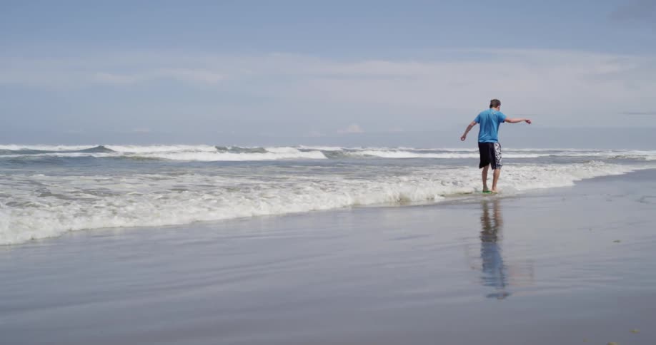 A man runs and slides in ocean waves