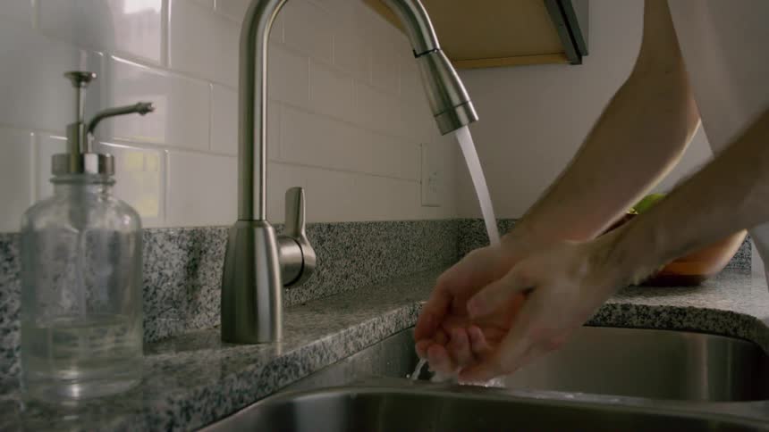Man washes his hands on the kitchen sink