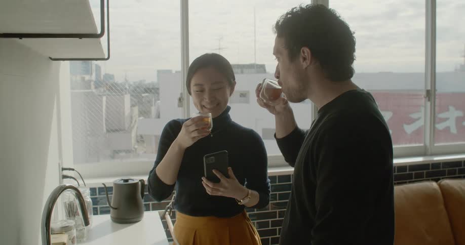 Two people toast glasses and on their hot drinks