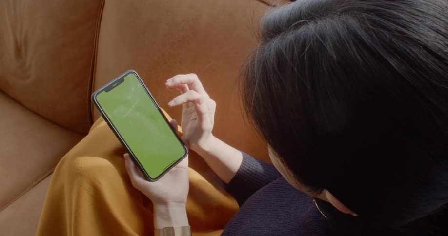 A woman sits and uses her cell phone