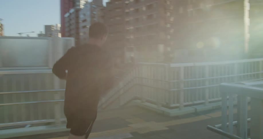 A man jogs along a pedestrian walking bridge