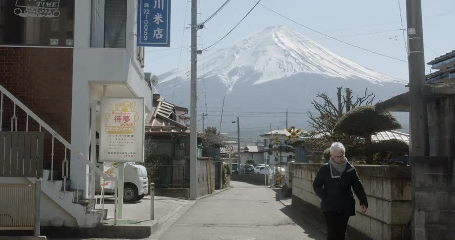 A woman walks along a quiet street near Mt Fuji