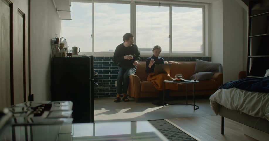 A man and woman sit on sofa