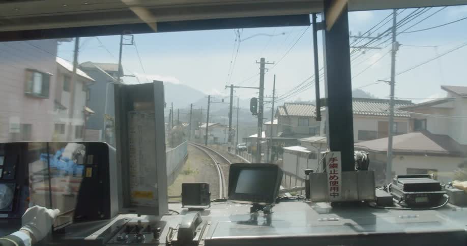 A woman drives a train down the tracks