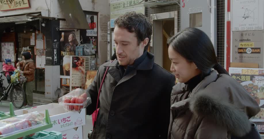 Couple buying fruit on street market in japan
