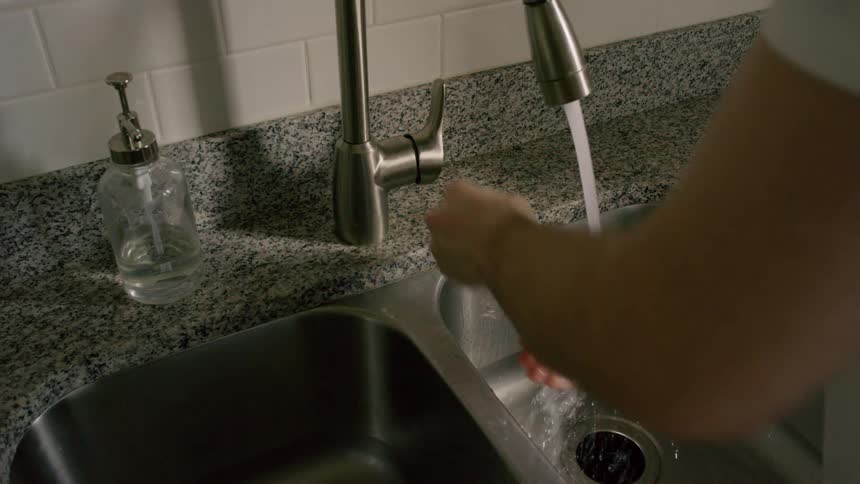 A man washing his hands in the sink
