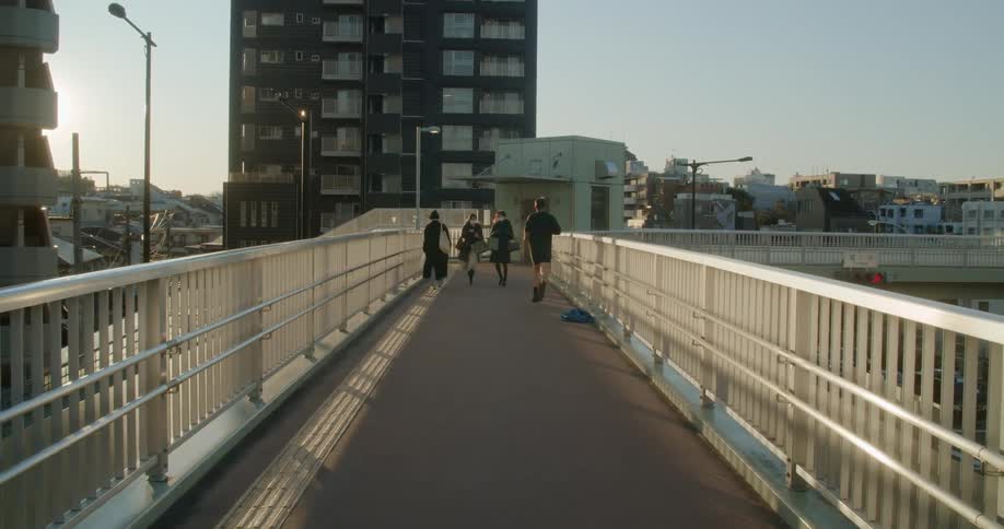 A man runs past people on a pedestrian bridge