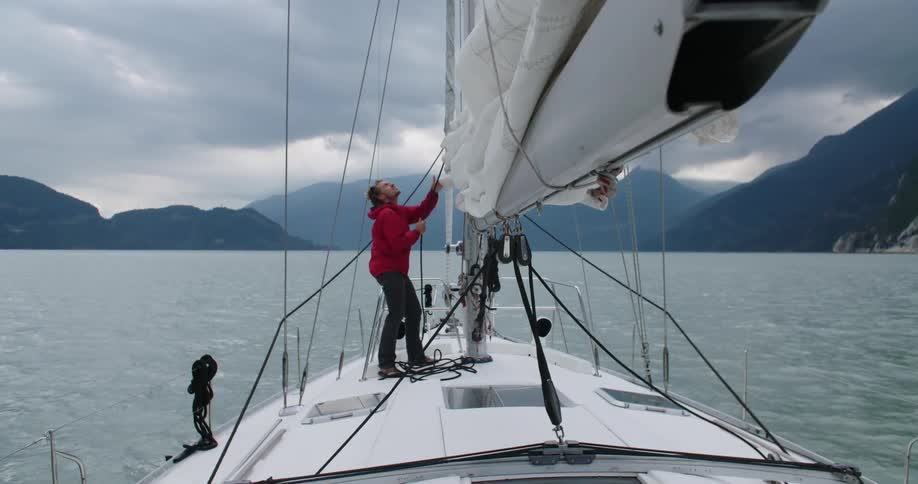 A man works on the boat sail