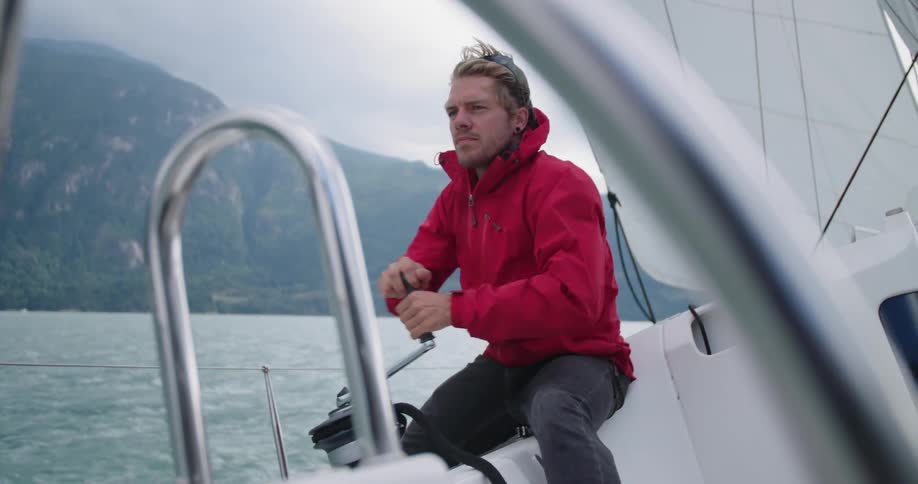 A man is sitting on a boat while on a body of water