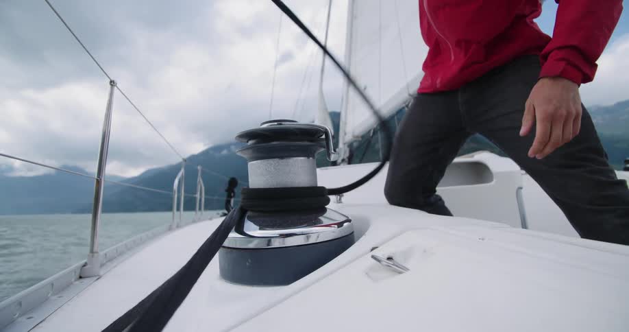 A man unravels a rope on a boat