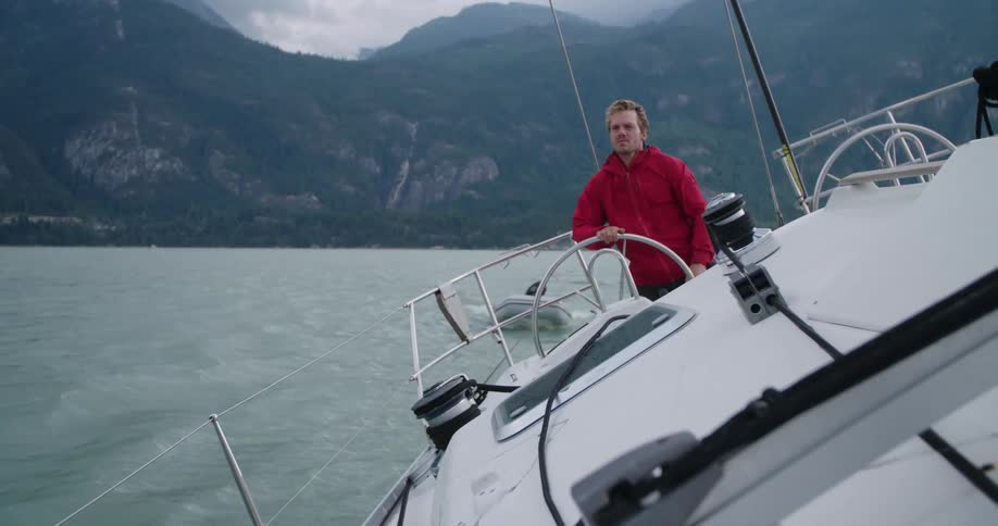 A man drives a yacht on a lake