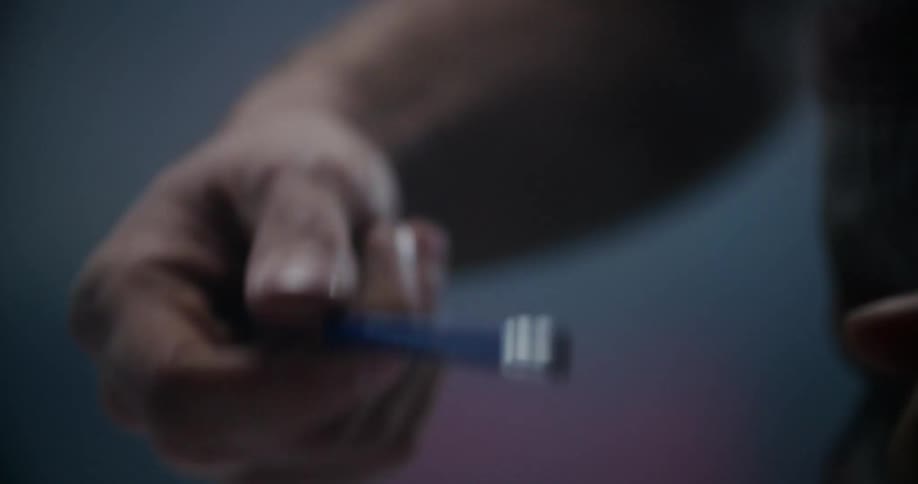 A man is holding a pencil indoors