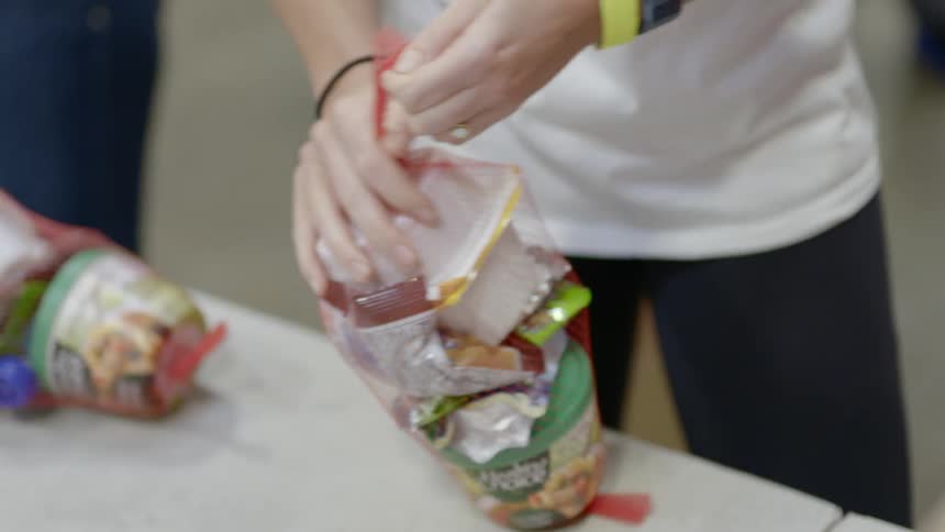 Woman secures end of mesh bag holding dry goods