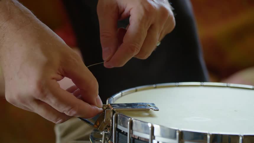 A man strings a banjo