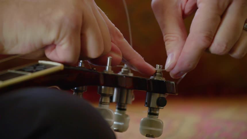 A man strings a guitar