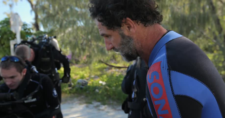 Divers prepare their equipment for a dive