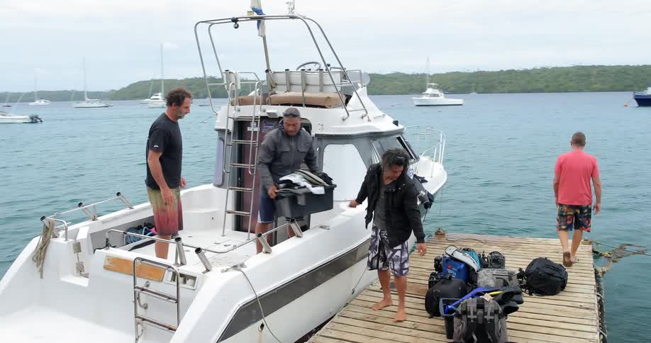 A group of men load up a small boat