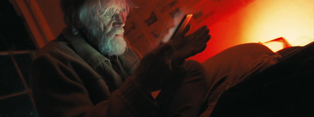 An old man ripping the plastic cover from a tablet screen causing white smoke to be emitting from the glowing display