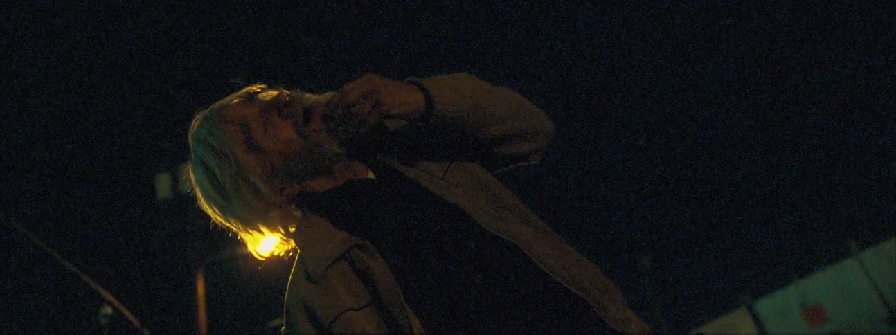 An elderly man rubs his beard as he has a mental breakdown outdoors at night
