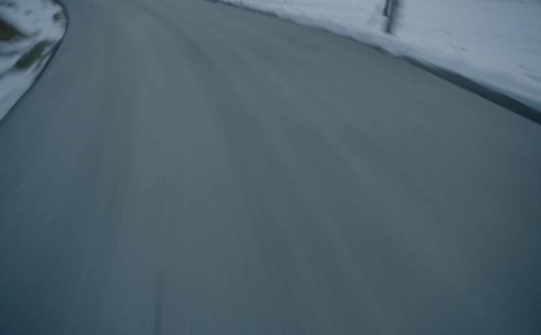Traveling down road between snow covered fields toward mountains