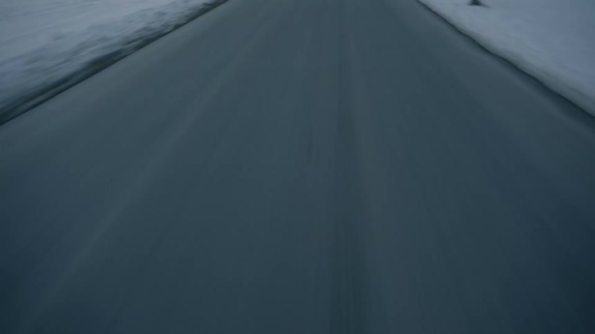 Vehicle drives along the road in the snowy countryside