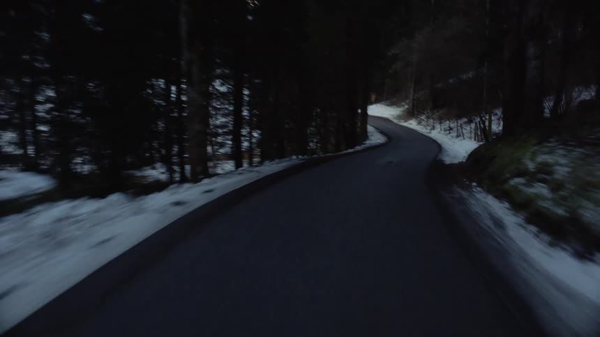 Road winds through forest among mountains