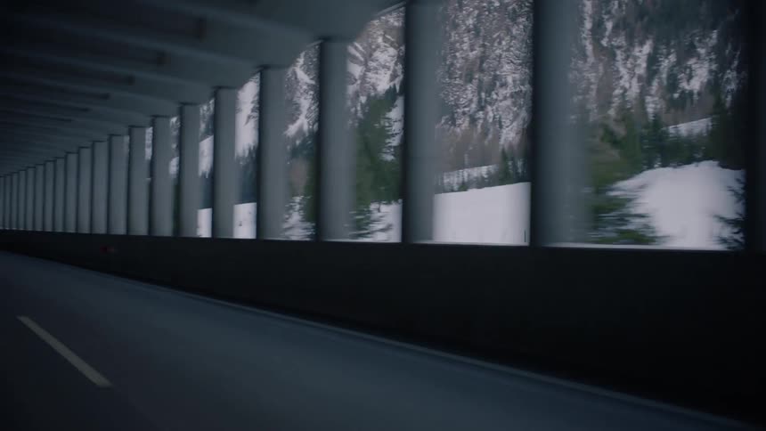 A car drives alongside a mountain range