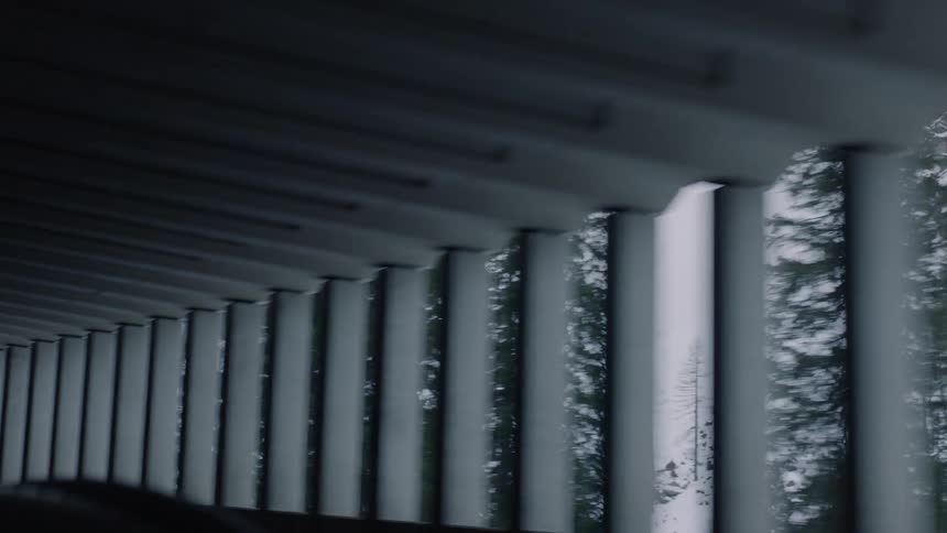 The vehicle travels under the overpass by the mountain