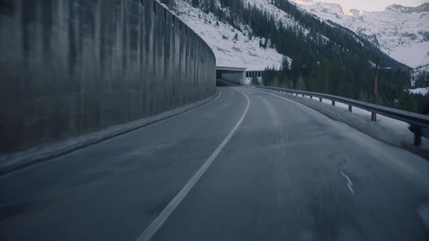 Driving through a tunnel on a mountain side road in the winter