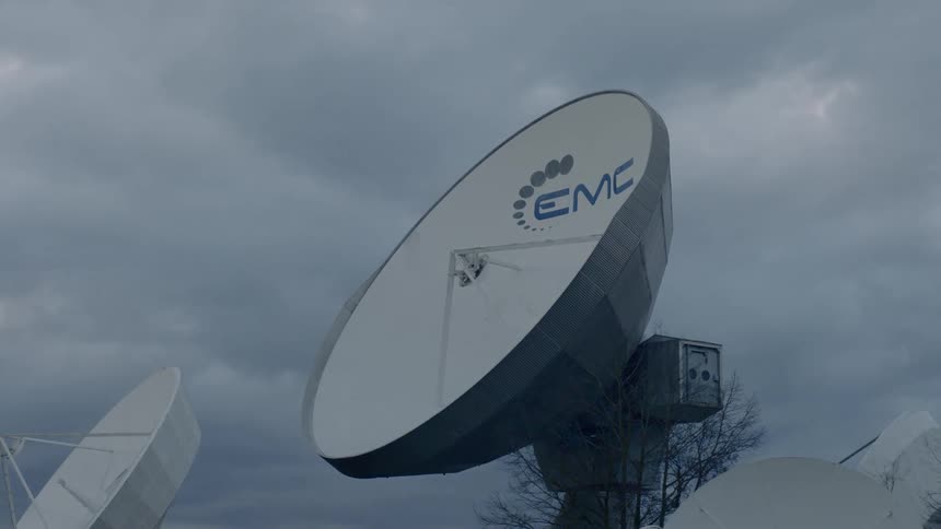 A satellite dish points towards a cloudy sky