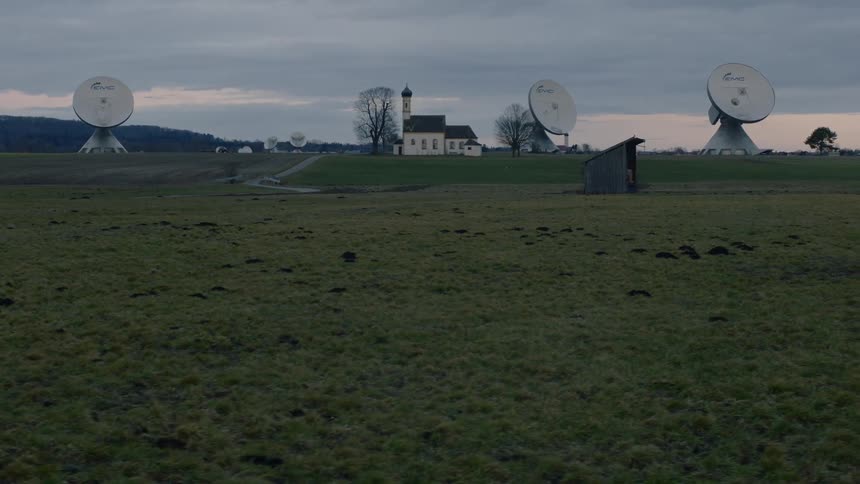 Satellite dishes near a house in an empty countryside at sunset