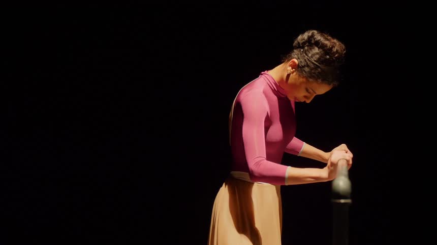 A dancer holds on to a bar